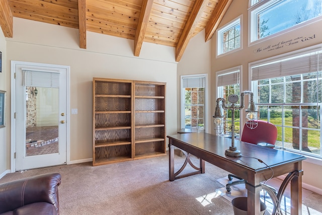 office space featuring plenty of natural light, beam ceiling, wood ceiling, and light colored carpet