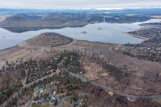 drone / aerial view featuring a water and mountain view