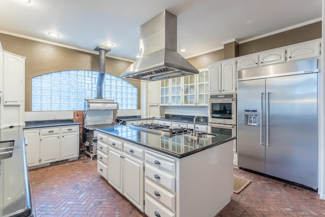 kitchen featuring white cabinetry, island range hood, appliances with stainless steel finishes, and tasteful backsplash