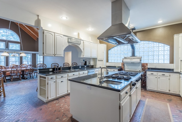 kitchen featuring white cabinetry, a center island with sink, island range hood, and plenty of natural light