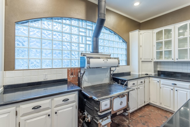 kitchen featuring dark stone countertops, tasteful backsplash, and white cabinetry