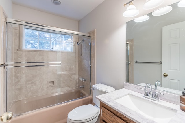 full bathroom featuring toilet, shower / bath combination with glass door, and vanity