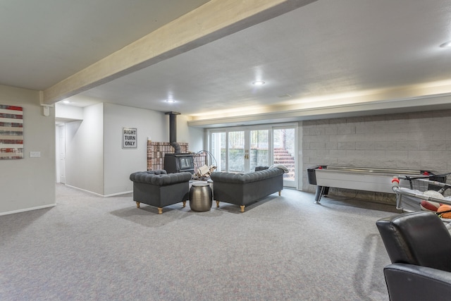 carpeted living room with a wood stove and beamed ceiling