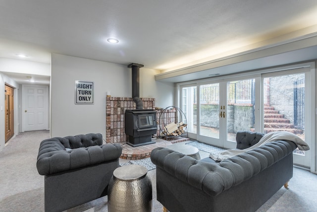 carpeted living room featuring french doors and a wood stove