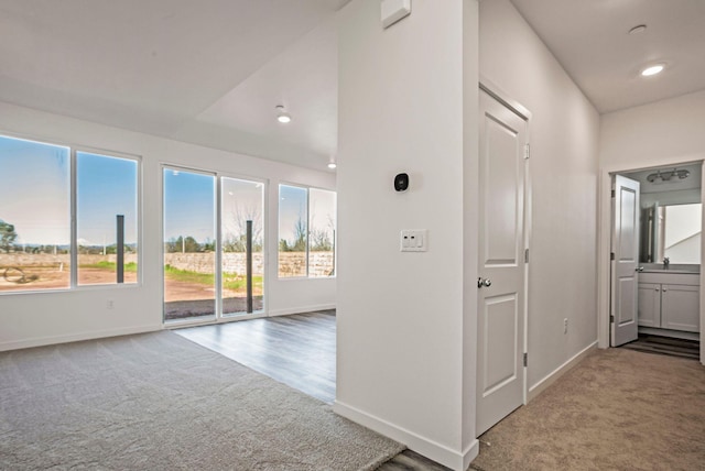 hall featuring light colored carpet