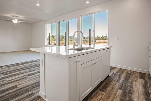 kitchen featuring ceiling fan, sink, dishwasher, white cabinetry, and a center island with sink