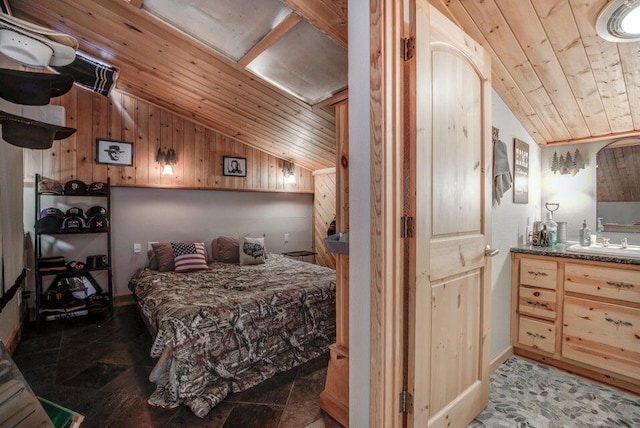 bedroom with wooden walls, dark tile flooring, sink, wood ceiling, and vaulted ceiling