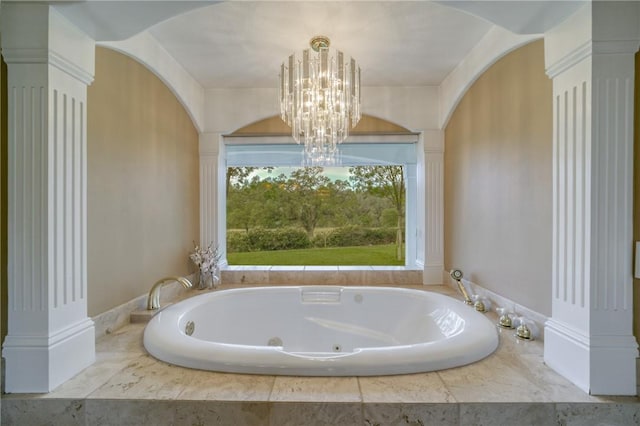 bathroom with decorative columns, a washtub, and a chandelier