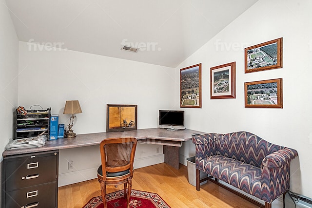 office area featuring lofted ceiling, light hardwood / wood-style floors, and built in desk