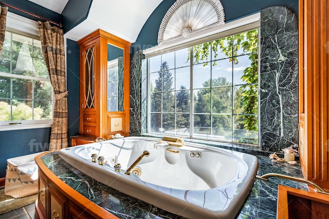 bathroom featuring tiled bath, tile floors, and plenty of natural light