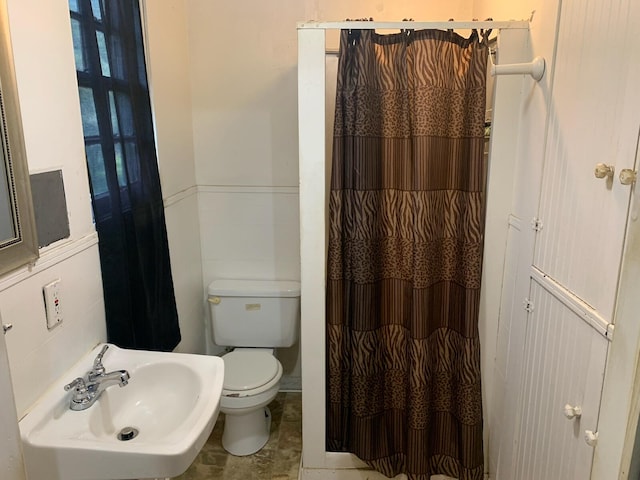 bathroom with toilet, tile floors, and sink