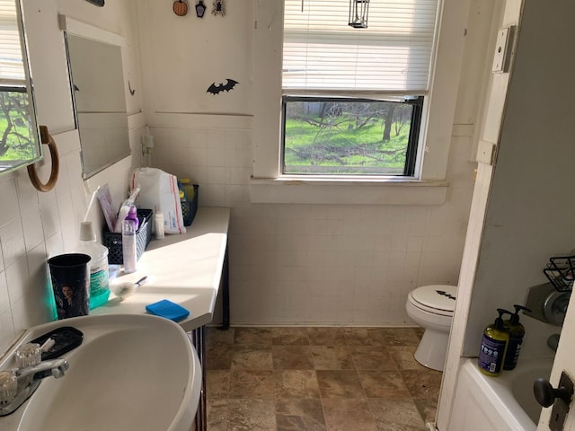 bathroom featuring tile walls, toilet, tile floors, and sink