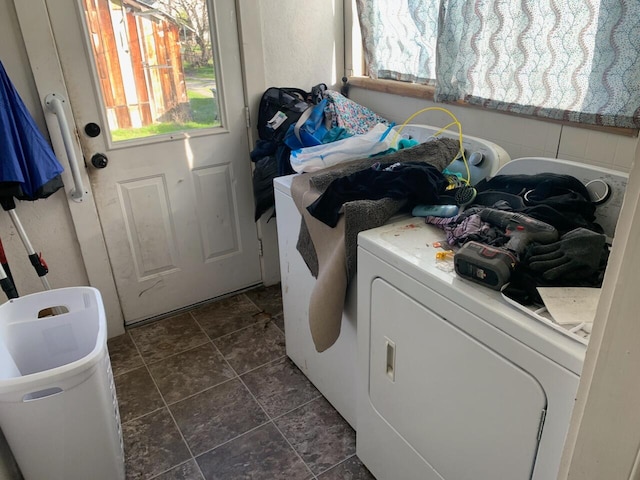 washroom featuring dark tile flooring and washer / dryer