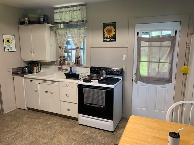 kitchen with white electric stove, white cabinets, sink, and light tile floors