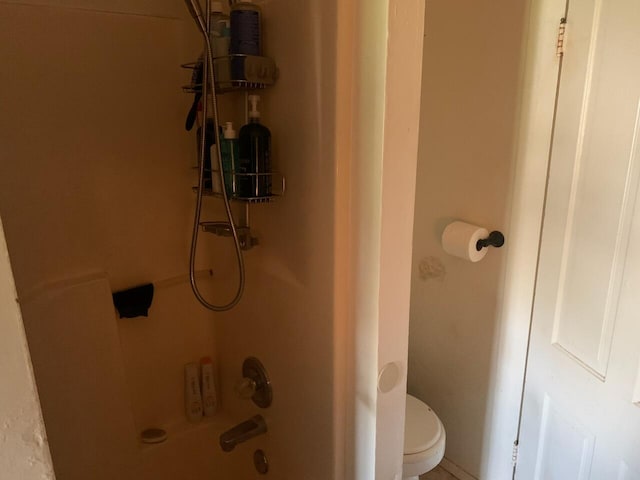 bathroom featuring shower / bathing tub combination and toilet