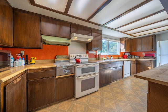 kitchen featuring sink, white appliances, light tile flooring, wall chimney range hood, and dark brown cabinets