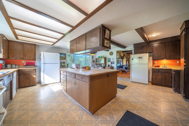 kitchen featuring dark brown cabinets, light tile floors, and white fridge