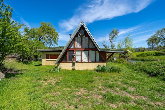 rear view of property featuring a lawn