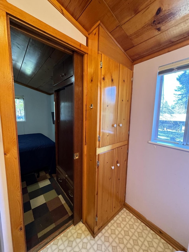 hallway featuring light tile flooring, a wealth of natural light, lofted ceiling, and wood ceiling