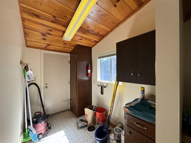 laundry area featuring light tile flooring and wooden ceiling