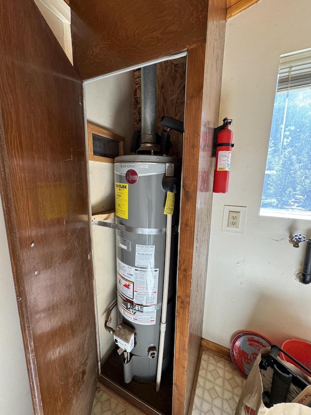 utility room featuring strapped water heater