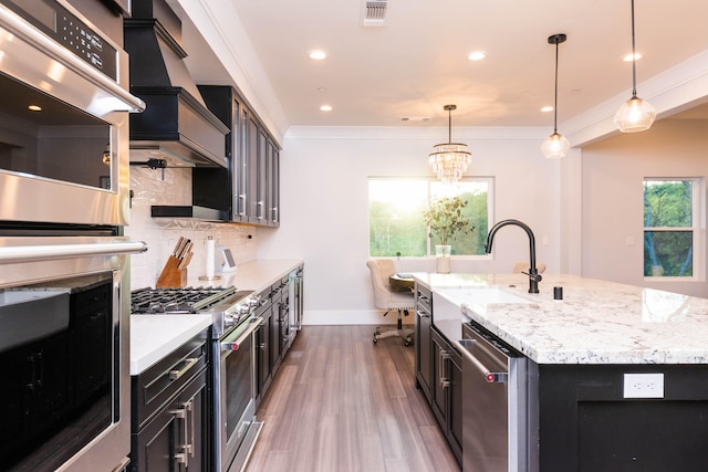 kitchen with dark hardwood / wood-style floors, a notable chandelier, an island with sink, stainless steel appliances, and tasteful backsplash