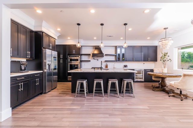 kitchen featuring a chandelier, a kitchen breakfast bar, beverage cooler, appliances with stainless steel finishes, and hanging light fixtures