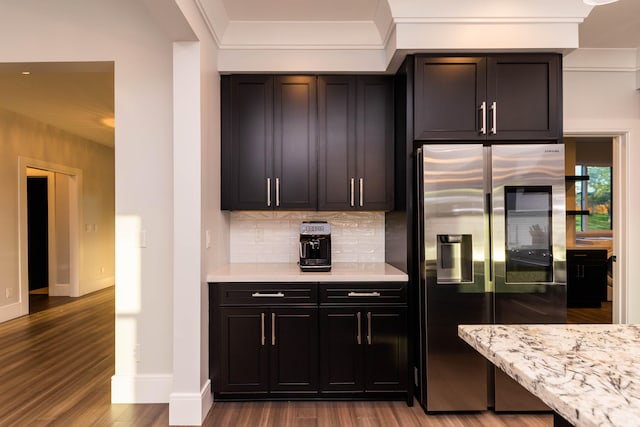 kitchen featuring high end fridge, light wood-type flooring, tasteful backsplash, and light stone countertops