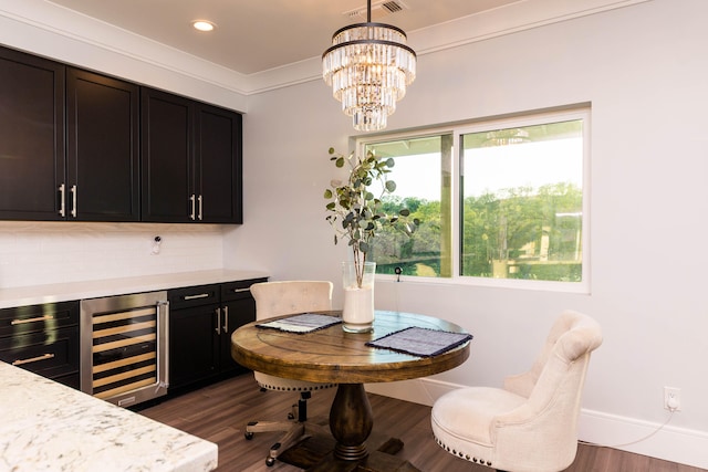 dining space featuring dark wood-type flooring, wine cooler, a chandelier, and a healthy amount of sunlight