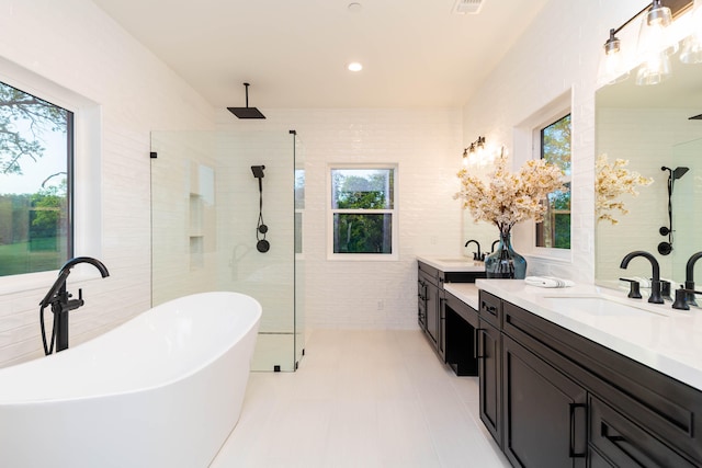 bathroom featuring tile walls, double sink vanity, plus walk in shower, and tile floors