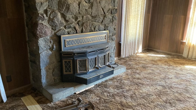 room details with dark colored carpet and a stone fireplace