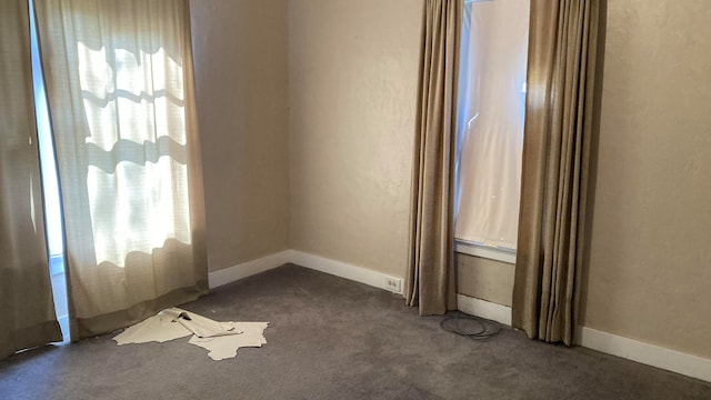 spare room with dark carpet