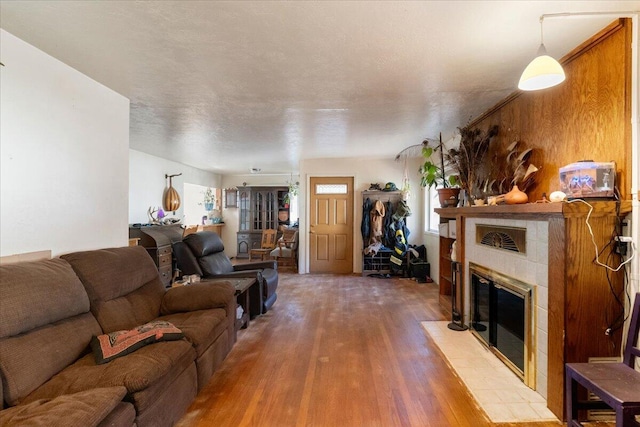 living room featuring a tile fireplace and light hardwood / wood-style flooring