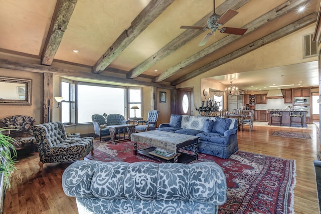 living room with lofted ceiling with beams, visible vents, wood finished floors, and ceiling fan with notable chandelier