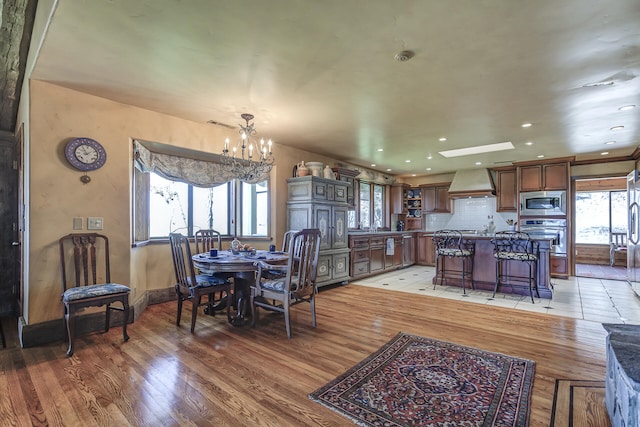 dining space featuring recessed lighting, light wood-style flooring, and a chandelier