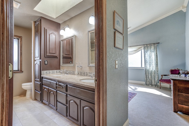 full bath with double vanity, tile patterned floors, toilet, and a sink