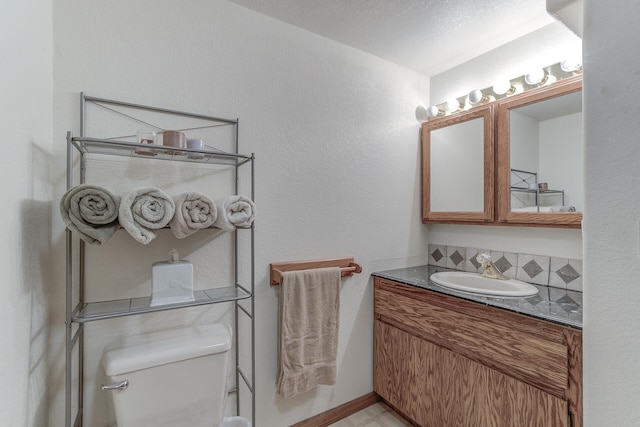 bathroom with decorative backsplash, toilet, and vanity