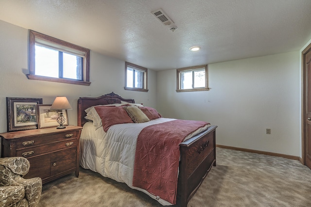 carpeted bedroom with visible vents, a textured ceiling, and baseboards