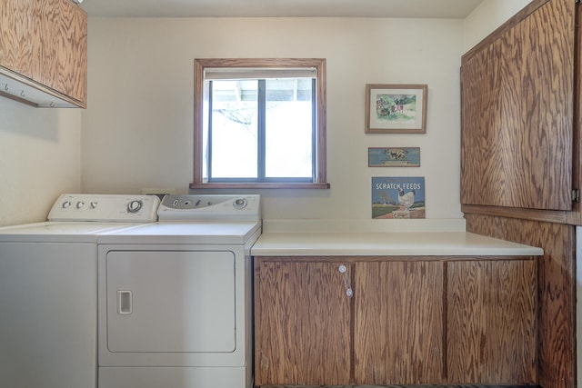 washroom with washer and clothes dryer and cabinet space