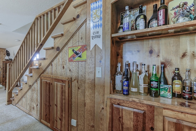 bar featuring stairway, a dry bar, and carpet