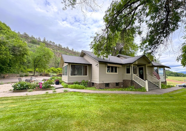 view of front of home featuring roof with shingles and a front yard