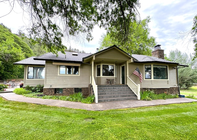 single story home with a front yard, roof with shingles, and a chimney