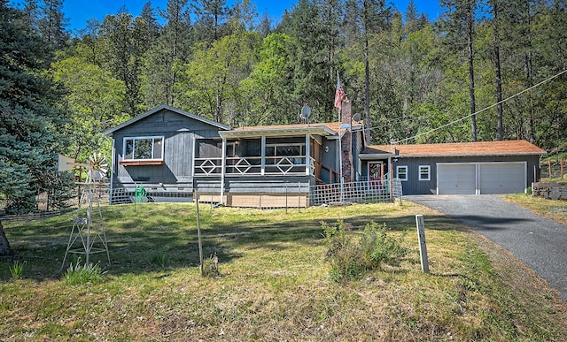 view of front of home with a front yard and a garage