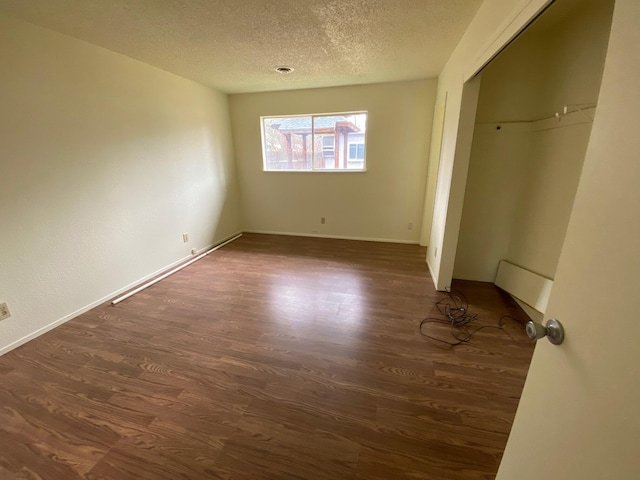 unfurnished bedroom with a closet, dark hardwood / wood-style floors, and a textured ceiling