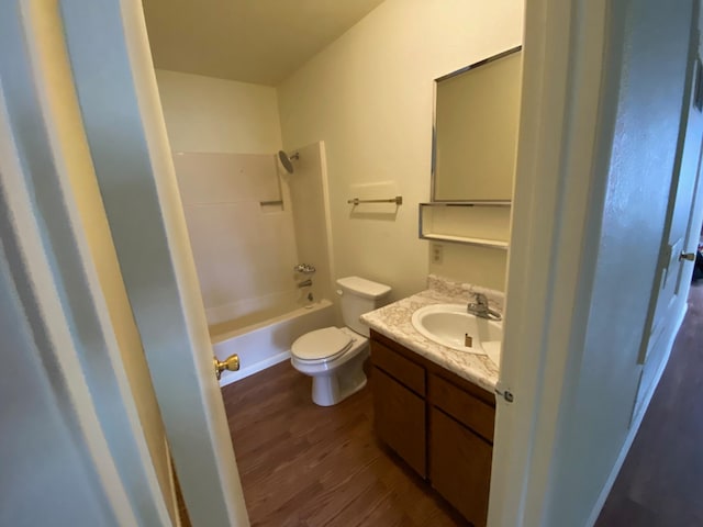 full bathroom with wood-type flooring, vanity with extensive cabinet space, toilet, and tub / shower combination