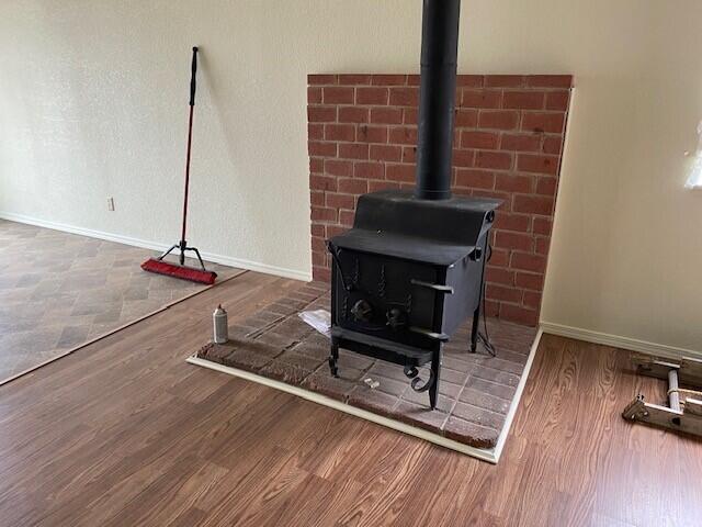 room details featuring a wood stove and dark wood-type flooring