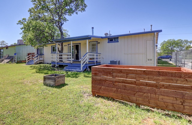 back of house with a yard, cooling unit, and a porch