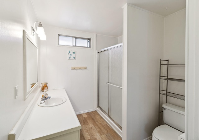 bathroom with hardwood / wood-style floors, vanity, a shower with door, and toilet