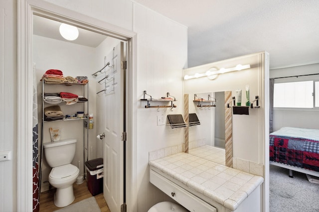 bathroom with toilet and wood-type flooring