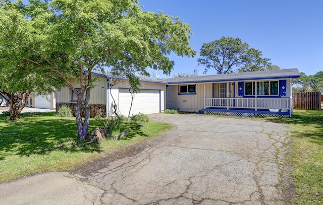 ranch-style house with a porch, a garage, and a front lawn